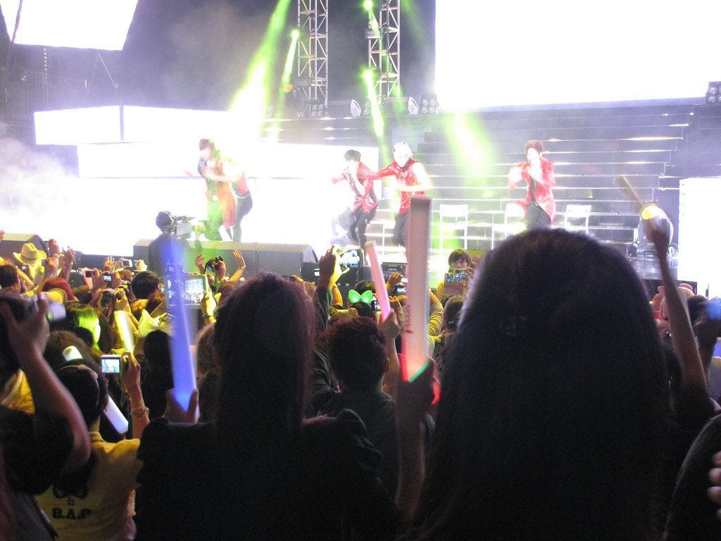 K-pop concert crowd holding lightsticks