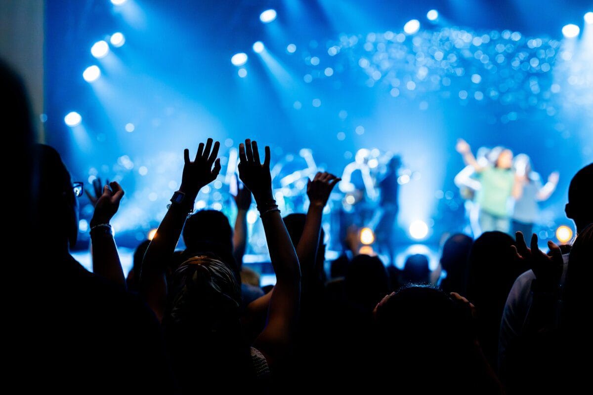 Concert crowd with hands raised, representing K-pop fandom culture
