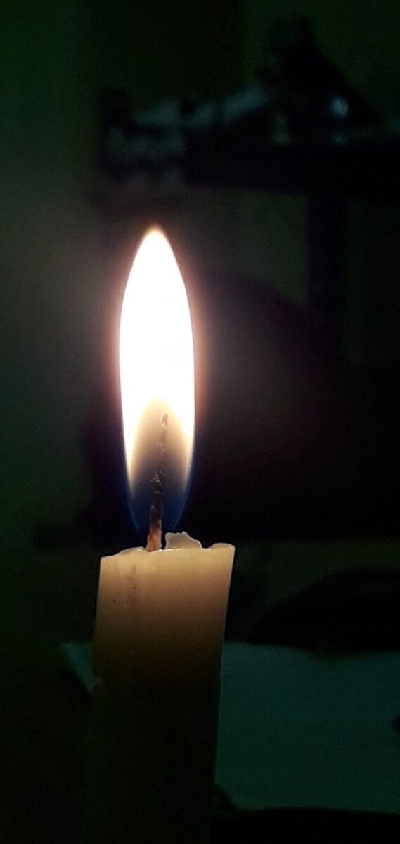 A lit wax candle, the raw material used to coat wakppu balls